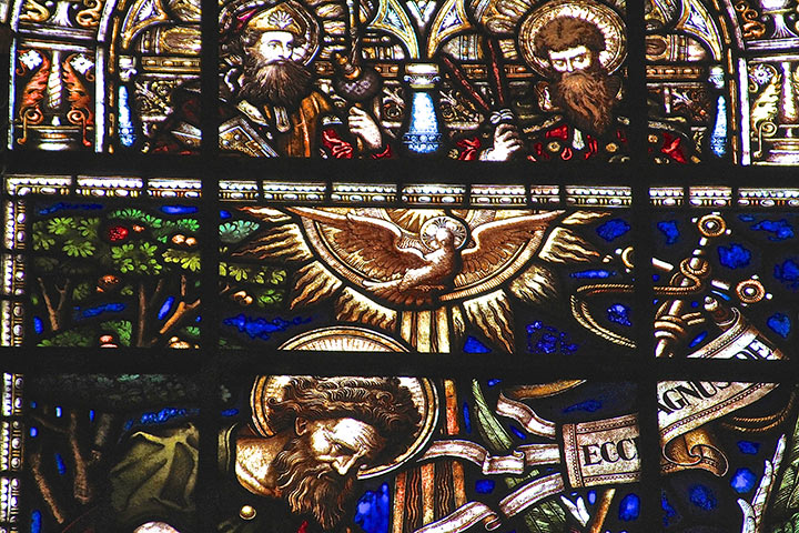 Detail of a stained glass window at Trinity with dove ascending.