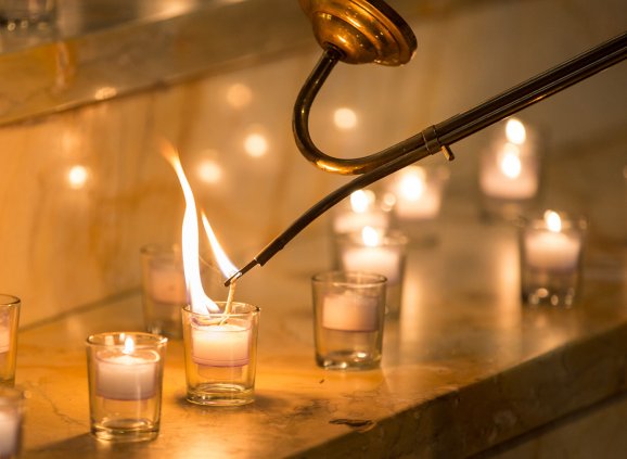Votive candles being lit