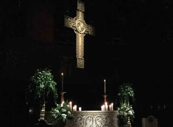 The cross and altar lit by candlelight.
