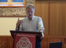 Mark Jordan speaks at a podium in the Forum of Trinity Church Boston