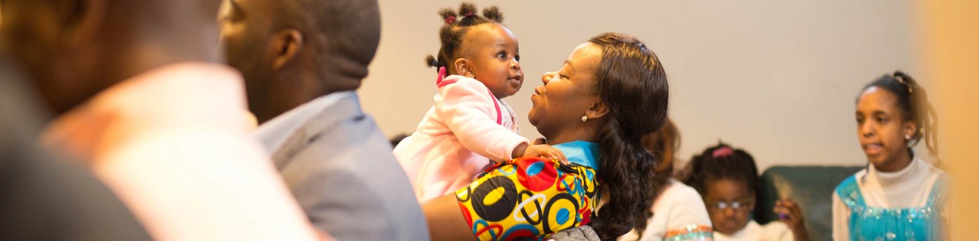 A mother smiles at her child during the Nigerian Christian Fellowship meeting.