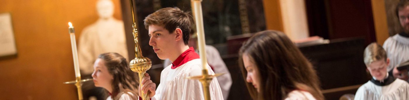 Acolytes carry torches and candles during a service.